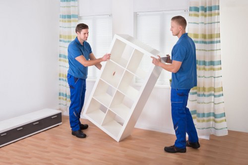 Movers carrying packed boxes and furniture during a house removal